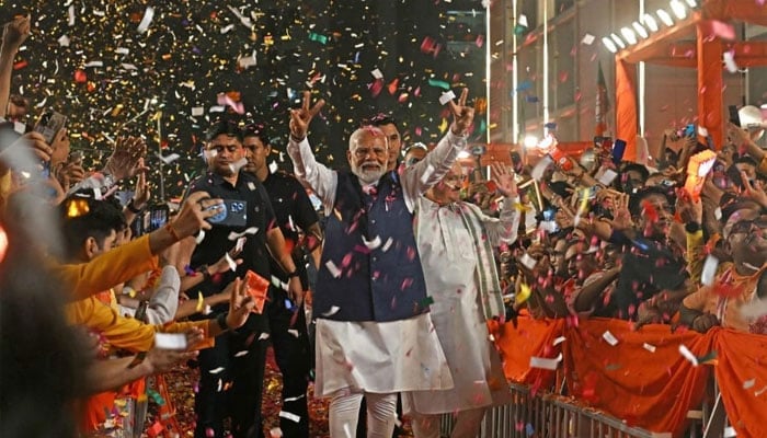 Indias Prime Minister Narendra Modi (C) flashes victory sign as he arrives at the Bharatiya Janata Party (BJP) headquarters to celebrate the partys win in countrys general election, in New Delhi on June 4, 2024. — AFP