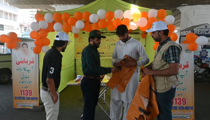The Rawalpindi Waste Management Company (RWMC) team distributes biodegradable bags and pamphlets to create awareness among the people at a camp on June 9, 2024. — Facebook/Rawalpindi Waste Management Company