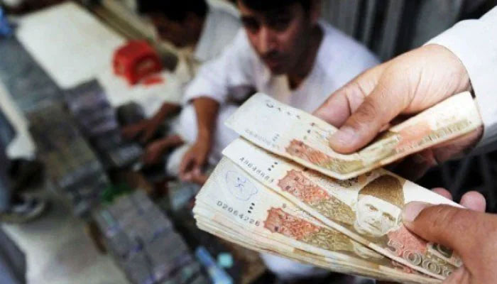 Money exchange broker seen counting Pakistani rupee. — AFP/File