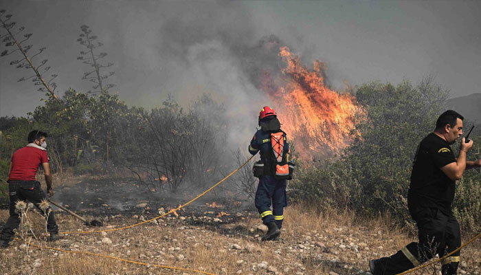 Firefighters and a civilian try to extinguish wildfires near the village of Vati, just north of the coastal town of Gennadi, in the southern part of the Greek island of Rhodes. — AFP/File
