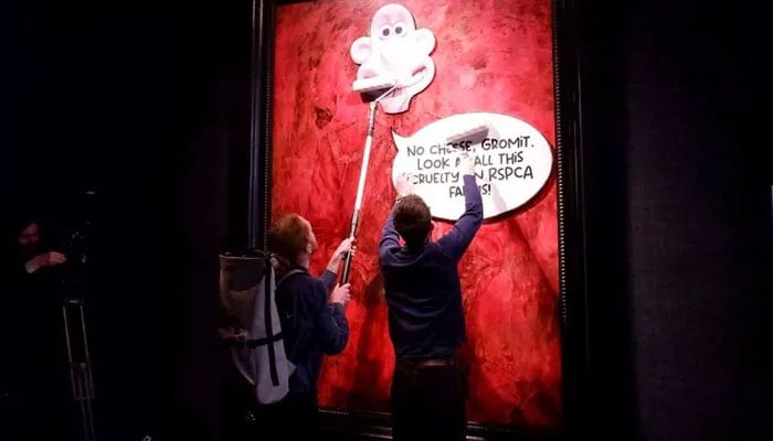 This photo released by Animal Rising shows activists pasting a picture of the character Wallace from the Wallace and Gromit comedy series over a portrait of Britains King Charles III at the Philip Mould Gallery in London, on Tuesday, June 11. — Animal Rising