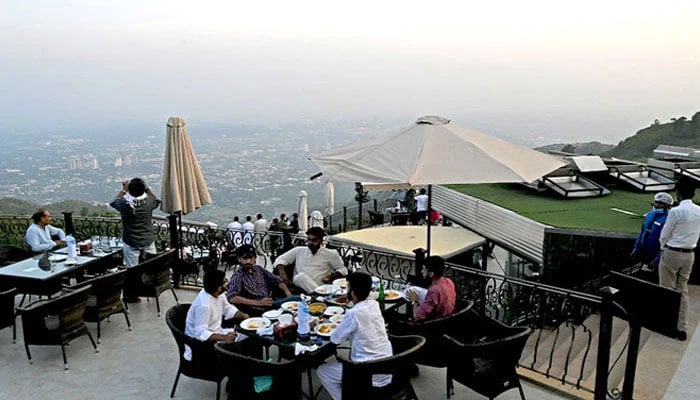 A representational image showing people dining at a restaurant at Islamabads Margalla Hills. — AFP/File