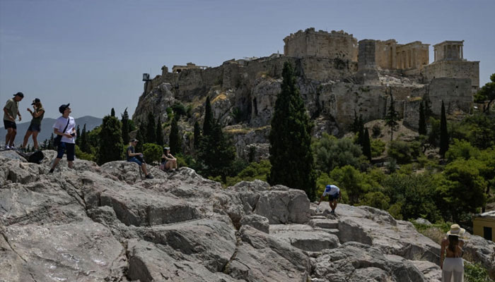 Athens Acropolis seen in the background with tourists in the front of this undated image. — AFP/file