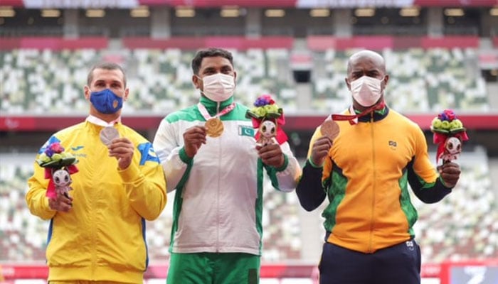 Ukraines Mykola Zhabnyak (L), Haider Ali (M) and Brazils Joao Victor Teixeira de Souza Silva (R) pose with their medals in discus throw at the Tokyo 2020 Paralympics Games. — X@ParalympicsGames