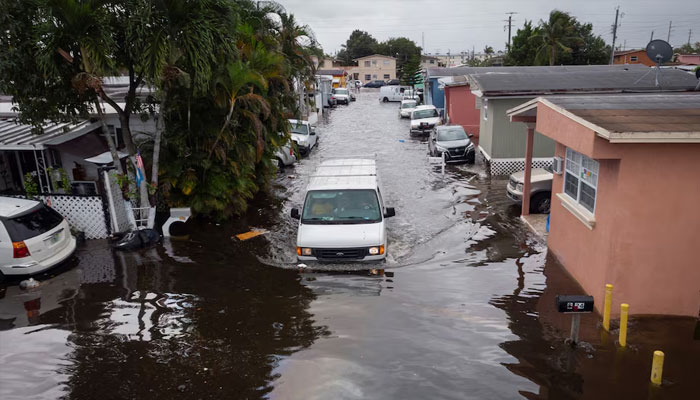 A car drives through flood water at a trailer park community in Hialeah, Florida, November 16. — Reuters