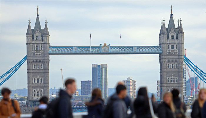 People walk over London Bridge looking at a view of Tower Bridge in the City of London financial district in London, Britain, October 25, 2023. — Reuters