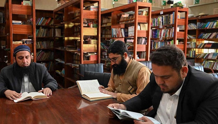 A representational image showing people reading books inside the Darra Adam Khel Library. — AFP/File