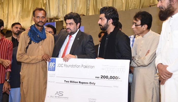 Sindh Governor Kamran Tessori (second left) and (MQM-P) Chairman and Federal Minister Khalid Maqbool Siddiqui (second right) and others hand over cheque to those affected by the cylinder blast in this image released on June 16, 2024. — X/@KamranTessoriPk