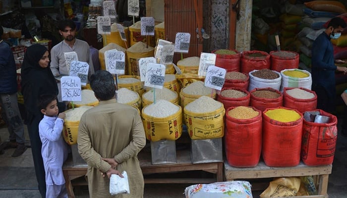 People buy pulses and grains at a wholesale market. — AFP/File