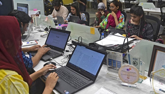 People work at their stations at the National Incubation Centre (NIC) in Lahore on May 24, 2019. — AFP