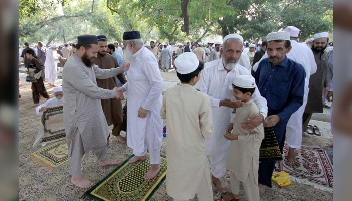 People embrace each other after Eid prayer on the occasion of 1st day of Eid ul Adha at Eidgah located on Charsadda Road in Peshawar on June 19, 2024. — PPI