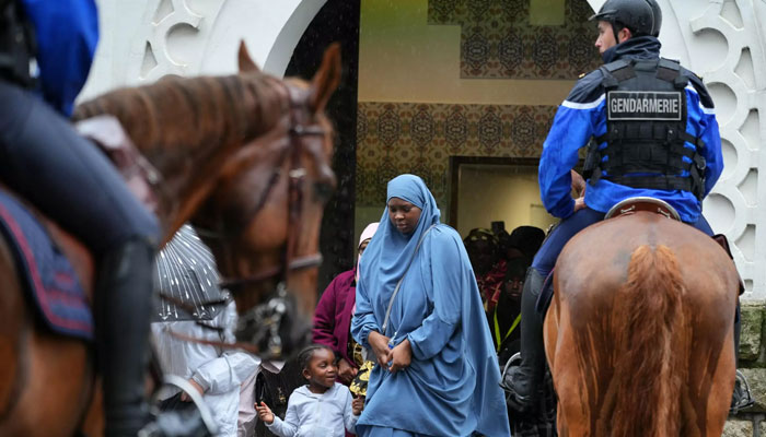 A Muslim woman stand along her daughter. — AFP/File