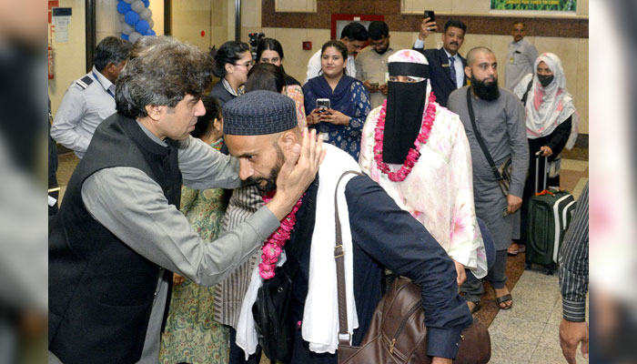 Director Hajj Punjab Muhammad Rizwan Sharif, Deputy Director Hajj Lahore Mujeeb Shah and others welcoming Hajaj Ikram and garlanding them with flowers on June 20, 2024. — APP