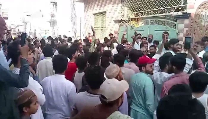 Violent mob gathers outside residence of man accused of committing blasphemy in Punjabs Sargodha district on May 25, 2024. — Screengrab via Geo News
