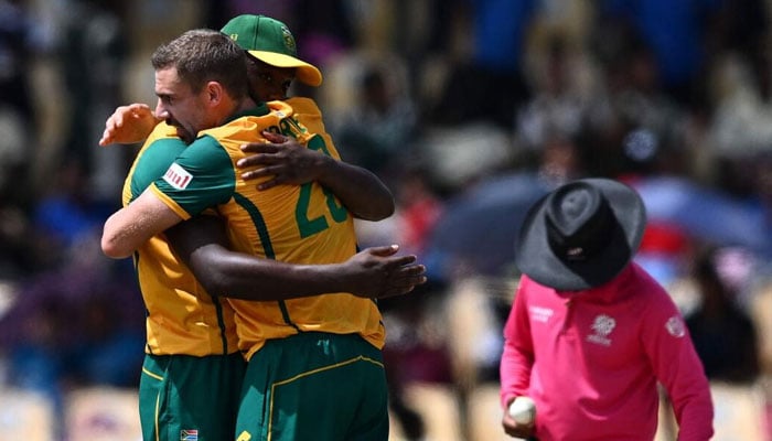 Kagiso Rabada embraces teammate Anrich Nortje after South Africa beat England on June 21, 2024. — AFP