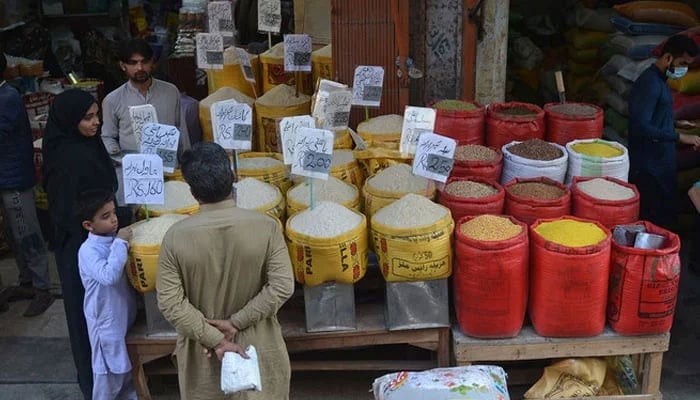 A representational image showing people buying pulses and grains at a wholesale market. — AFP/File