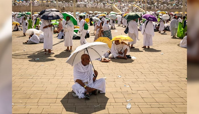 Muslim pilgrims use umbrellas to shade themselves from the sun as they arrive at the base of Mount Arafat during the Hajj. — AFP/File
