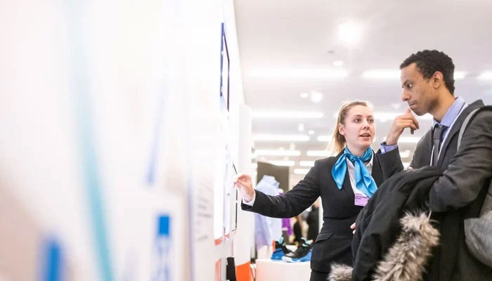 A woman speaks while pointing to a board a s a man listens during a professional interaction in this representational image. — Unsplash/File