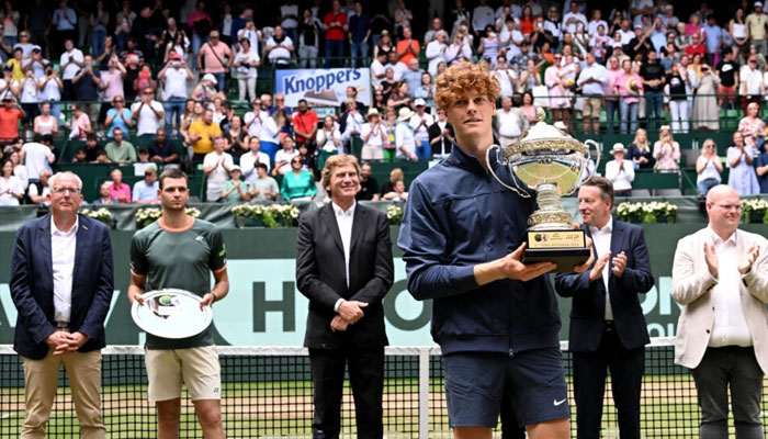 Italys world number one Jannik Sinner with the trophy after winning his first grass-court title in Halle.— AFP/file