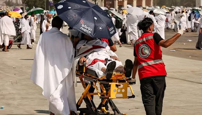 Medical team members evacuate a Muslim pilgrim, affected by the soarching heat, at the base of Mount Arafat during the annual Hajj pilgrimage. — AFP/file