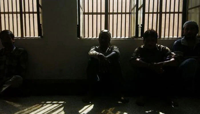 Prisoners sitting inside a dark lockup are seen in this undated image. — AFP/File