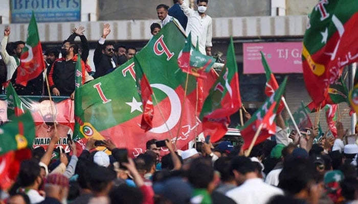 Supporters of the PTI party waves flags at a protest rally in Karachi on January 28, 2024. — AFP