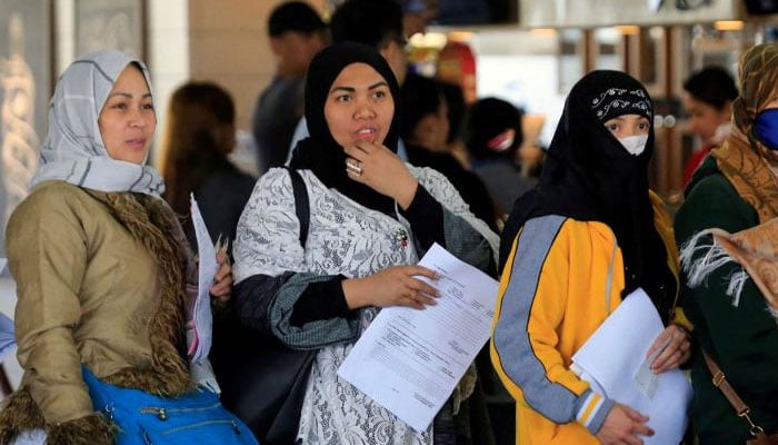 Overseas Filipino Workers from Kuwait hold their documents as they queue upon their arrival at the Ninoy Aquino International Airport in Pasay city, Metro Manila, Philippines. — Reuters/file