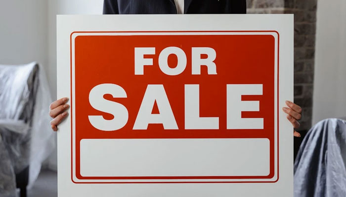 A representational image of  a person holding a placard with For Sale written on it. — Pexels/File