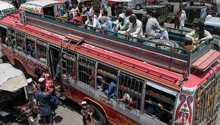 People travel in an overcrowded bus in Lahore on June 15, 2024. —  AFP