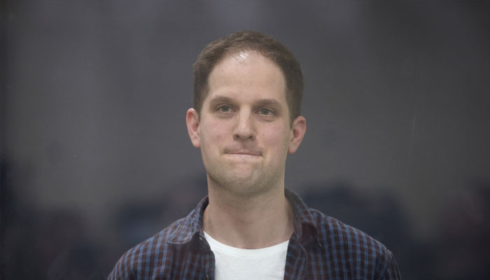 Wall Street Journal reporter Evan Gershkovich, who is in custody on espionage charges, stands behind a glass wall of an enclosure for defendants during a court hearing in Moscow, Russia, April 23, 2024. — Reuters