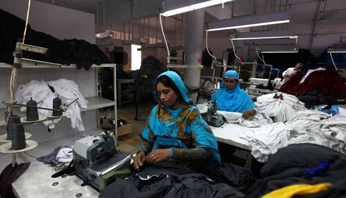 Workers at a garment factory seen stitching loose fabric. — Reuters/File