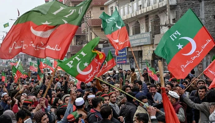 Supporters and activists of Pakistan Tehreek-e-Insaf (PTI) wave party flags in Peshawar on January 28, 2024. — AFP