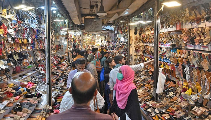 A representational image showing people shop at a market in Lahore. — AFP/File