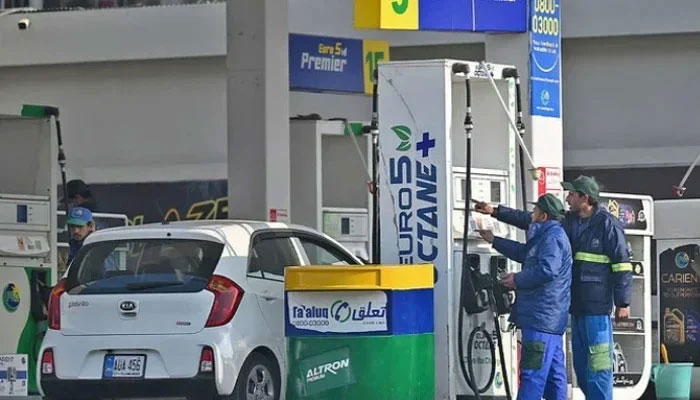 Employees at a fuel station attend to their customers in Islamabad, Pakistan. — AFP/File