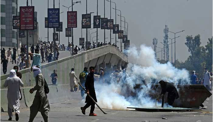 PTI activists and supporters of former prime minister Imran Khan, clash with police during a protest against the arrest of their leader in Peshawar on May 10, 2023. — AFP