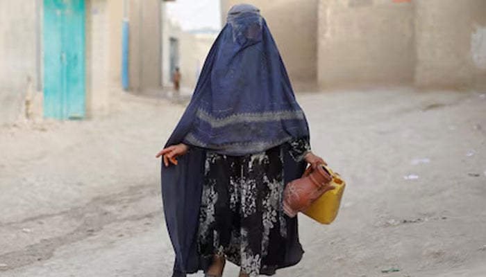 An Afghan woman carries empty containers to fetch water in Nahr-e-Shahi district in Balkh province, Afghanistan, August 6, 2023. — Reuters