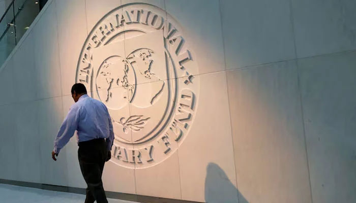 A man walks past the International Monetary Fund (IMF) logo at its headquarters in Washington, US, May 10, 2018. — Reuters