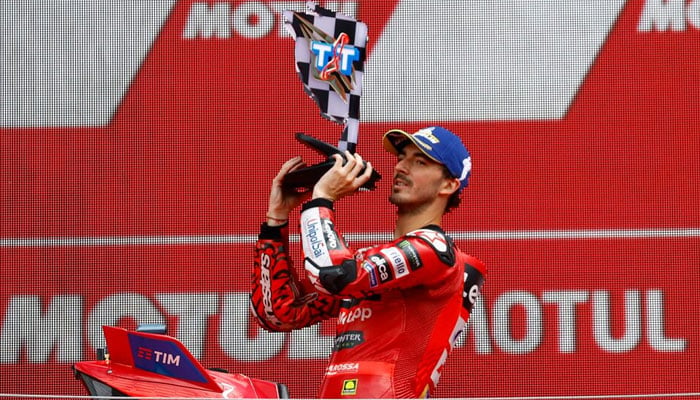 Francesco Bagnaia celebrates on the podium with a trophy after winning the TT Assen Grand Prix in Netherlands on June 30, 2024. — Reuters