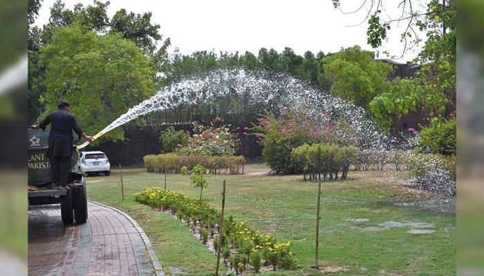 PHA staffer watering the plants to keep them fresh in Lahore on June 30, 2024. — APP