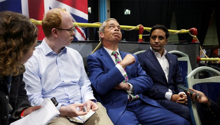 Britains Reform UK Party Leader Nigel Farage reacts while sitting with Zia Yusuf, the Reform UK partys largest donor, and reporters during interviews following a rally at the NEC in Birmingham, Britain, June 30, 2024. — Reuters