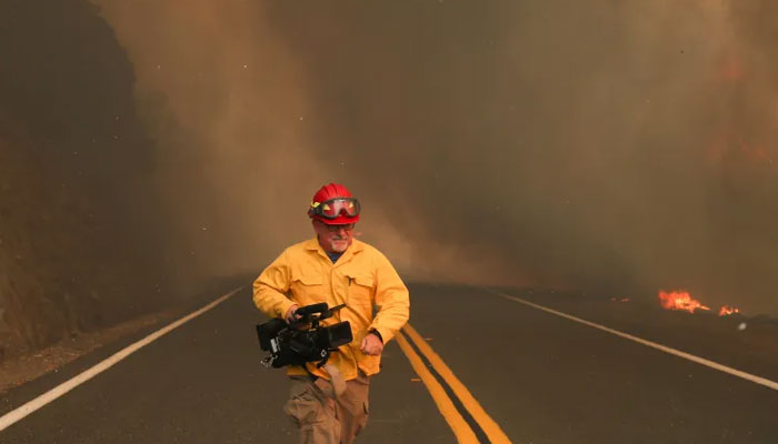 A journalist pictured with a camera as he covers a fire in Lake County, California, on August 23, 2020. — Reuters