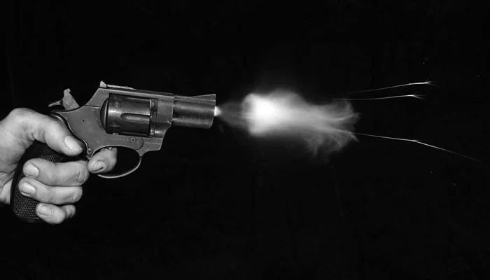 A person firing a bullet from a gun. — Unsplash File