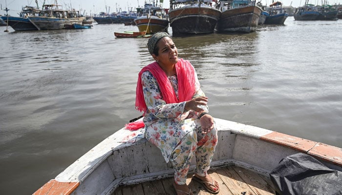 Neha Mankani, a midwife speaks during an interview as she sits near the shoreline at Baba Island along the Karachi Harbour, in Karachi on July 2 2024. — AFP