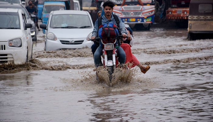 Vehicles passing through rain water accumulated on the Korangi road during heavy rain experienced in Karachi on February 4, 2024. — APP