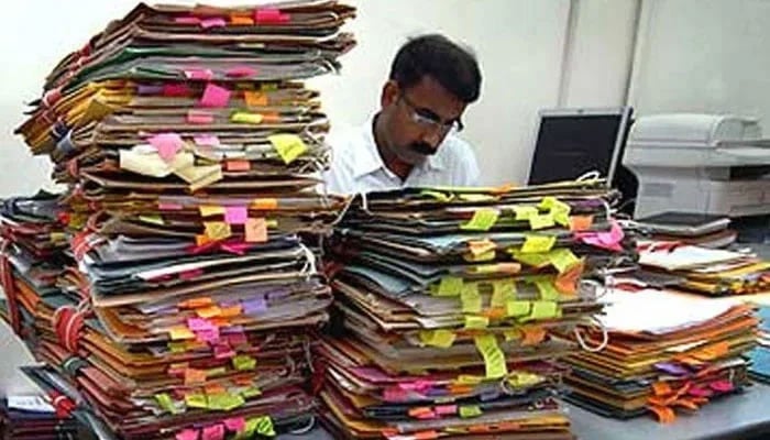 A representational image of a government employee working in his office. — Geo News/File
