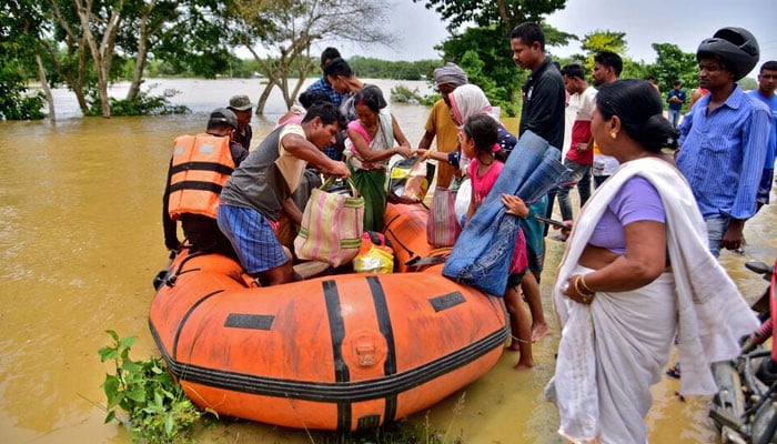 People disembark a boat after they were evacuated from a flooded village in Nagaon district, in the northeastern state of Assam, India, on May 18, 2022. — Reuters