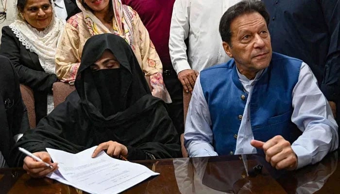 Pakistan´s former Prime Minister, Imran Khan (R) along with his wife Bushra Bibi appear before registrar office in the High court, in Lahore on July 17, 2023. — AFP
