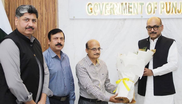P&D Board Chairman Barrister Nabeel Ahmad Awan (R) presents a flower bouquet to the retired officer in this image released on July 4, 2024. — Facebook/Planning & Development Board, Govt. of the Punjab