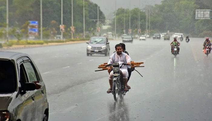 Motorists ride towards the Srinagar Highway during heavy rainfall in Islamabad on June 25, 2023. — Online