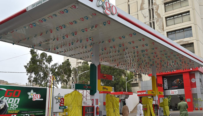 Commuters walk past a closed fuel station amidst a nationwide strike to protest against the hike in tax, in Karachi on July 5, 2024. — AFP